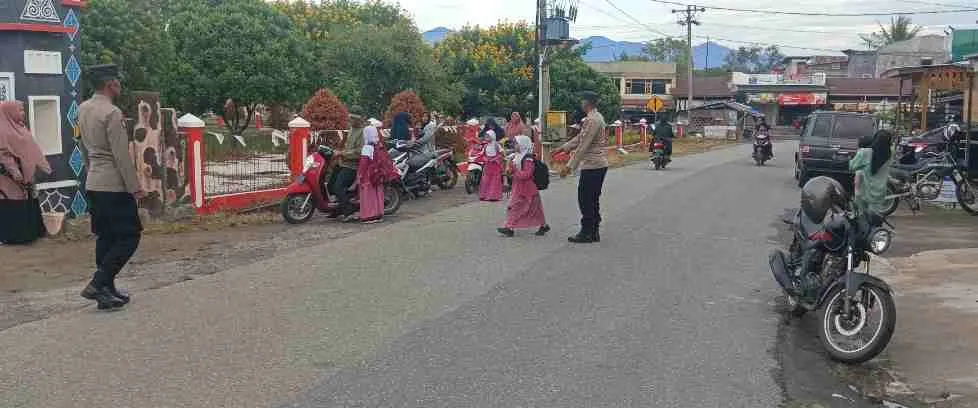 Polisi Hadir untuk Masyarakat, Polsek Ketol Bantu Pelajar Menyeberang di Jam Sibuk