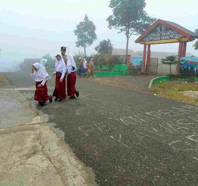 Polsek Jagong Jeget Dampingi Siswa Menyeberang Jalan di Tengah Kabut Pagi, Prioritaskan Keselamatan Pelajar