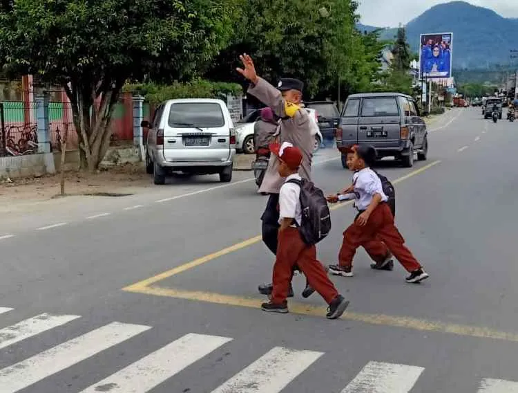 Polisi Hadir di Pagi Hari, Bantu Pelajar Menyeberang di Tengah Padatnya Aktivitas Warga